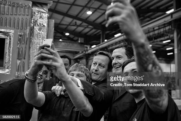 Prime Minister David Cameron and Chancellor George Osborne pictured taking 'selfies' with apprentices at Spooner engineering works in Ilkley,...