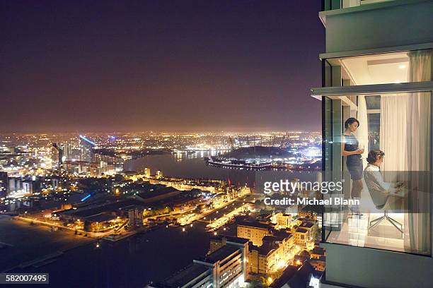 business couple in city apartment at night - luxury apartment stock pictures, royalty-free photos & images