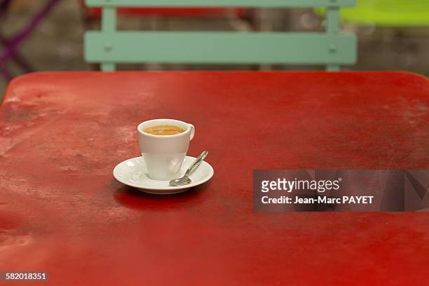 coffee cup on a old iron red table - jean marc payet stock-fotos und bilder