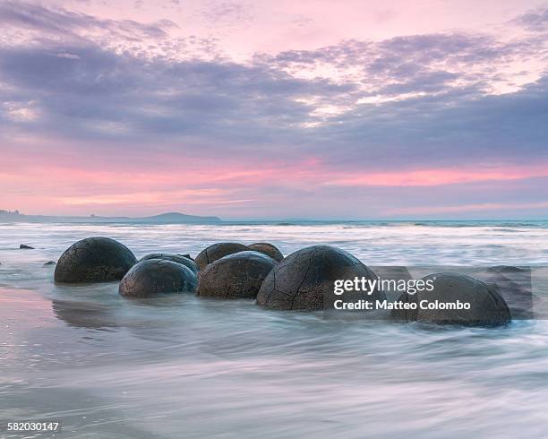 famous moeraki boulders at sunset, new zealand - moeraki boulders ストックフォトと画像