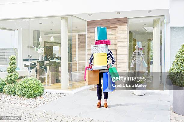 woman hidden by her shopping bags and boxes - トートバック ストックフォトと画像