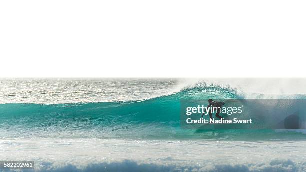 surfer silhouette on blue wave - surfboard stock pictures, royalty-free photos & images
