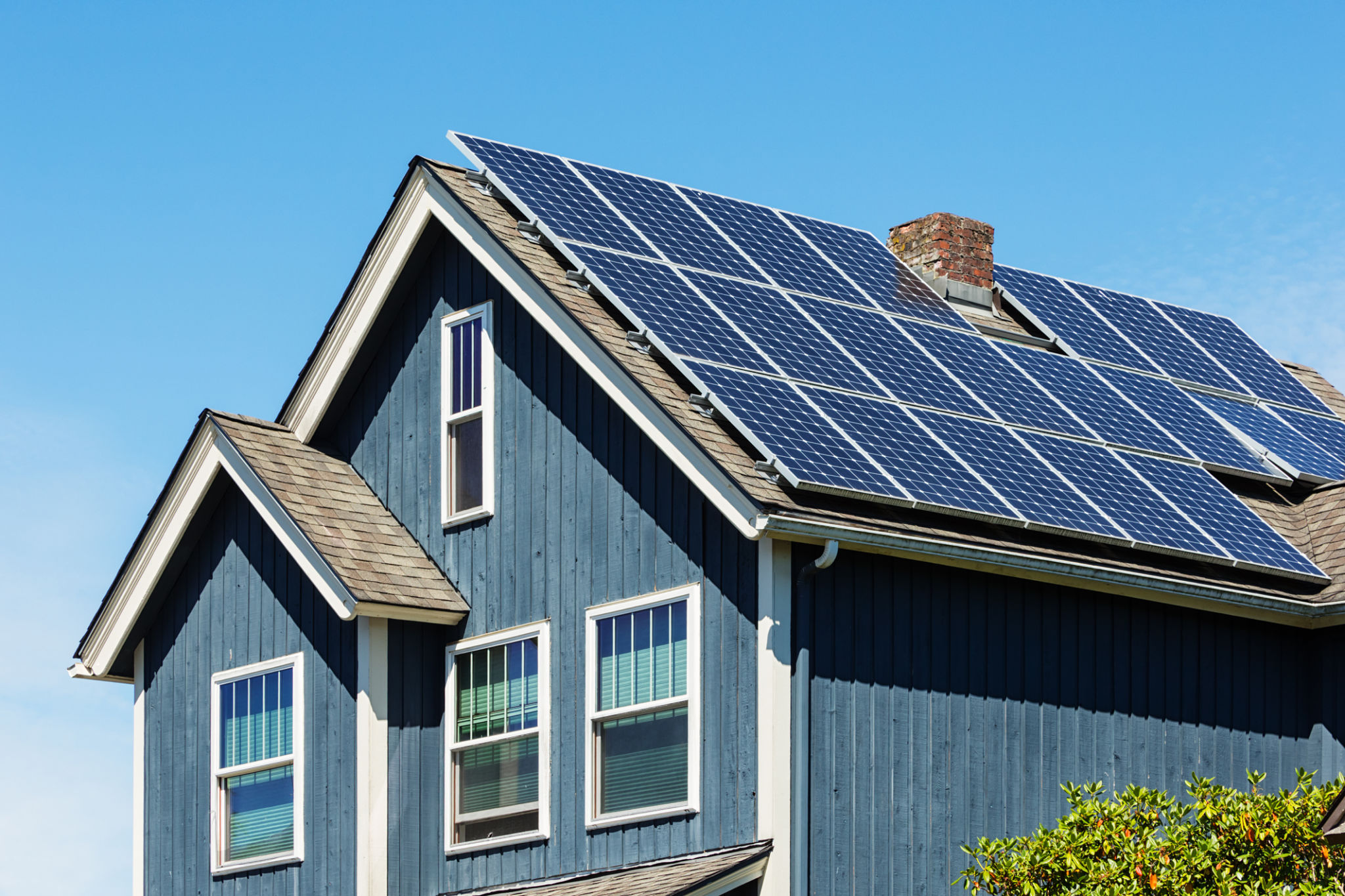 Traditionelles amerikanisches Haus mit modernen Sonnenkollektoren auf dem Dach Traditionelles amerikanisches Haus mit modernen Sonnenkollektoren auf dem Dach