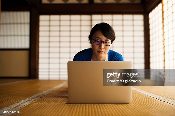 woman using a laptop in a japanese temple - tatami mat stock pictures, royalty-free photos & images