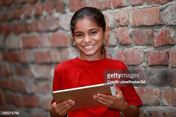 little cute happy girl holding tablet - childhood poverty stock pictures, royalty-free photos & images
