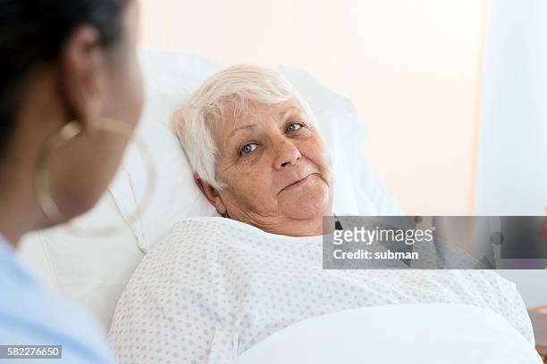 senior woman patient with female doctor - bedside manner stock pictures, royalty-free photos & images