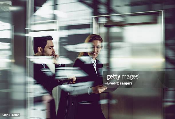 two business coworkers walking along elevated walkway - office motion stock pictures, royalty-free photos & images