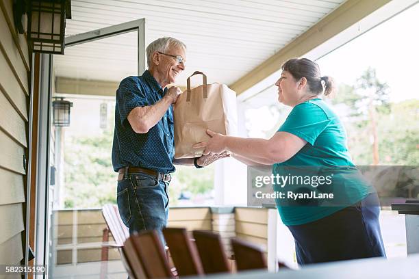 delivering groceries to senior man - neighbor stock pictures, royalty-free photos & images