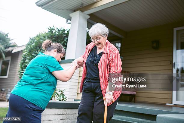 friend provides assistance to senior woman - friendly neighbor stock pictures, royalty-free photos & images
