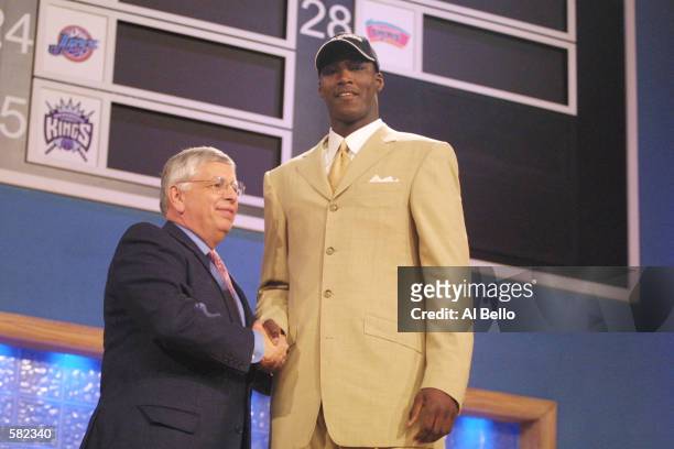 Commissioner David Stern congratulates Kwame Brown of Glynn Acadamy in Brunswick, Georgia, after being the first pick in the NBA Draft by the...
