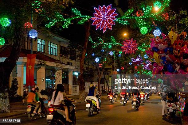 neon lights line a street during the new year in ho chi minh city, vietnam - ho chi minh photos et images de collection