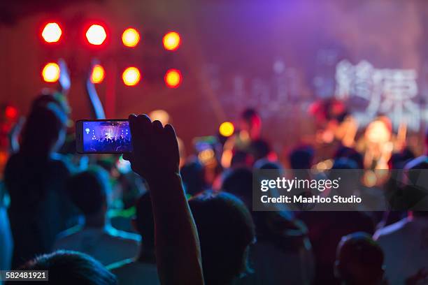 crowd using smart phone at rock concert - concierto fotografías e imágenes de stock