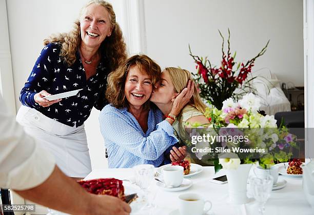 friends enjoying teatime eating raspberry cake at home - oma feiert stock-fotos und bilder