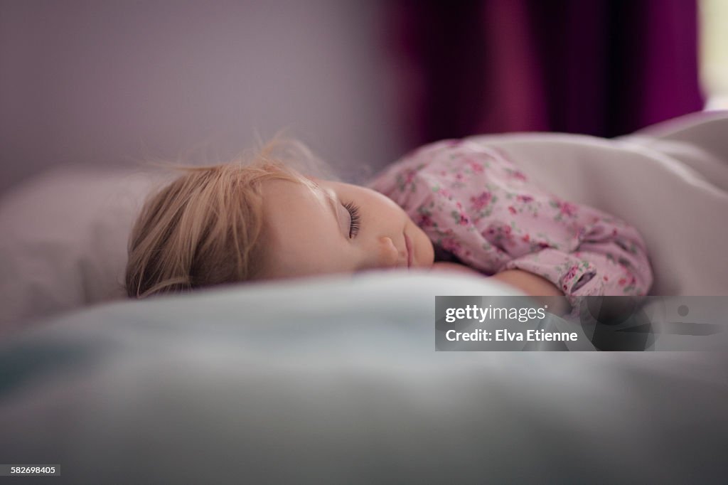 Todler girl (2-3) sleeping on bed