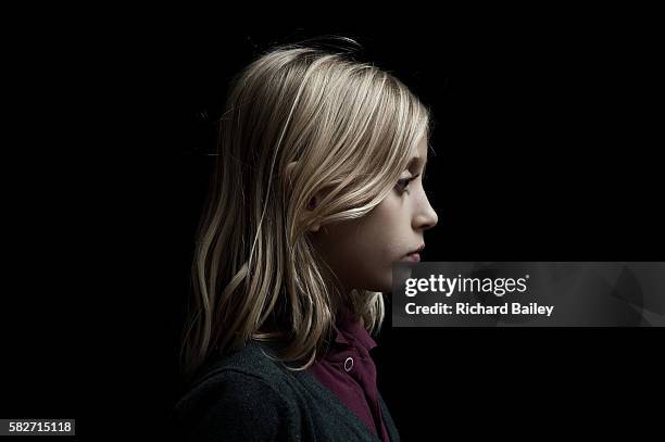 side portrait of small girl - blonde hair black background stock pictures, royalty-free photos & images