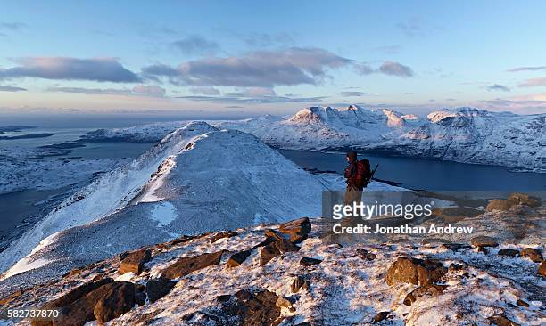 winter hiker overlooking mountain lake - highlands schottland wandern stock-fotos und bilder