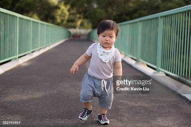 toddler boy walking on a footbridge - 赤ちゃんの靴 ストックフォトと画像