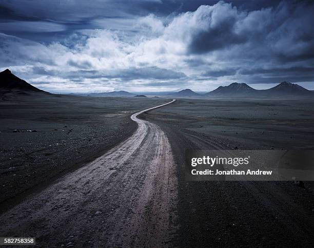 road running through desolate mountainous area - ominous stock pictures, royalty-free photos & images