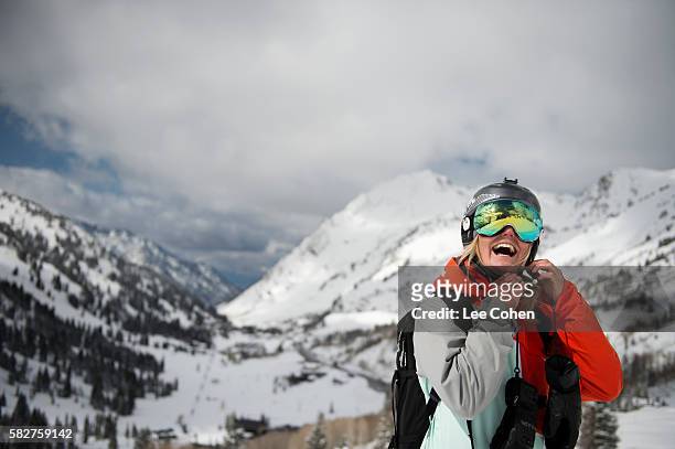 happy woman skier buckling helmet strap - wintersport foto e immagini stock