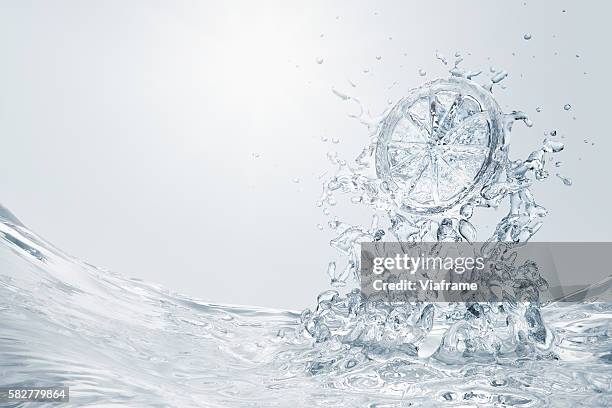 slice of lemon splashing into water - lemon soda stock pictures, royalty-free photos & images