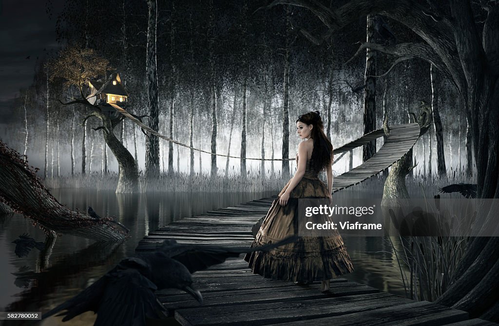 Woman standing on footbridge leading to treehouse (digital composite)