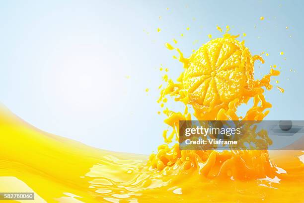 slice of orange splashing into orange juice - splash jus d'orange stockfoto's en -beelden