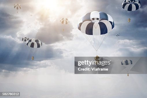 Parachutes with dollar sign falling from sky Parachutes with dollar sign falling from sky