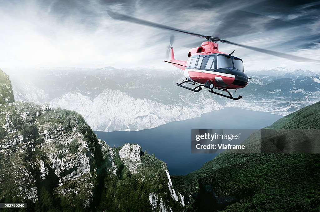 Helicopter flying over mountains and a lake