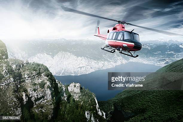 helicopter flying over mountains and a lake - helicóptero - fotografias e filmes do acervo