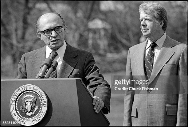 United States President Jimmy Carter stands behind Israeli Prime Minister Menachem Begin, while Begin addresses the press after a round of...