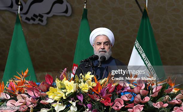 Iranian President Hassan Rouhani delivers his speech under a portrait of the late revolutionary founder Ayatollah Ruhollah Khomeini during a rally to...