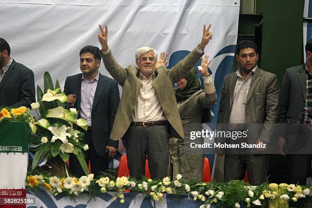 Iranian former Vice-President Mohammad Reza Aref and his wife Hamideh Moravej Tafreshi wave to supporters during a campaign rally for Aref in Tehran...
