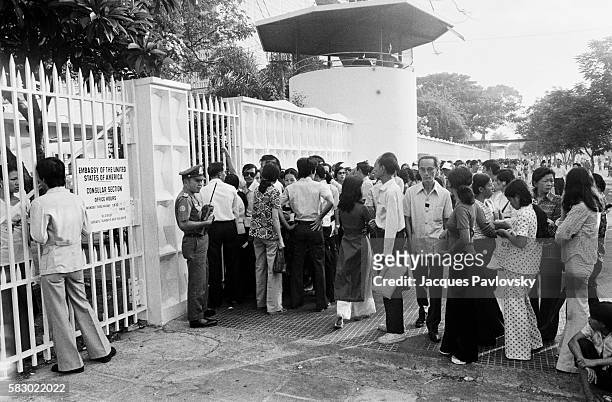 Queues form outside the American Embassy in the hope of securing visas available to wives, Vietnamese mothers married to Americans and staff working...