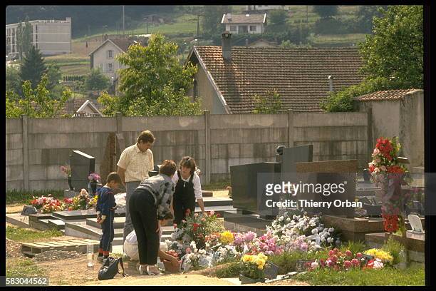 Christine Villemin avec sa soeur déposant des fleurs sur la tombe de son fils Gregory Villemin.