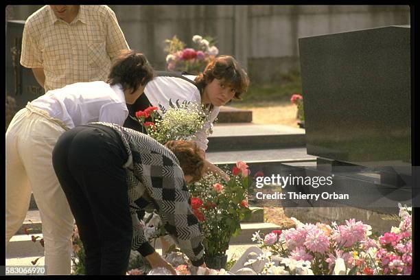 Christine Villemin avec sa sœur déposant des fleurs sur la tombe de son fils Gregory Villemin.