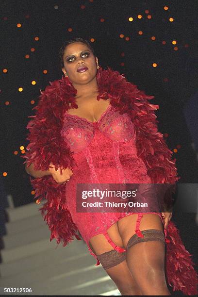 Plus size model wearing a hot pink lace one piece corset and brassiere with garters, dark stockings and a hot pink feather boa at the Ronde de Nuit...