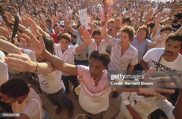 Their arms stretched to the sky, delegates from the ecclesial base communities of Liberation Theology come together for their sixth meeting,...