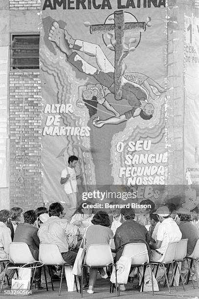 During the sixth meeting of the ecclesial base communities of Liberation Theology, delegates gather beneath a huge banner proclaiming "May the blood...