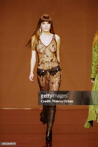 Fashion model wears a Lolita Lempicka Ready-To-Wear women's fashion ensemble during a Fall-Winter 2000-2001 fashion show. The outfit includes a...
