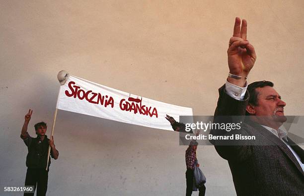 Poles hold a Stocznia Gdynia shipyard banner aloft just behind Lech Walesa in a rally against the closure of the Gdansk shipyards, the cradle of the...