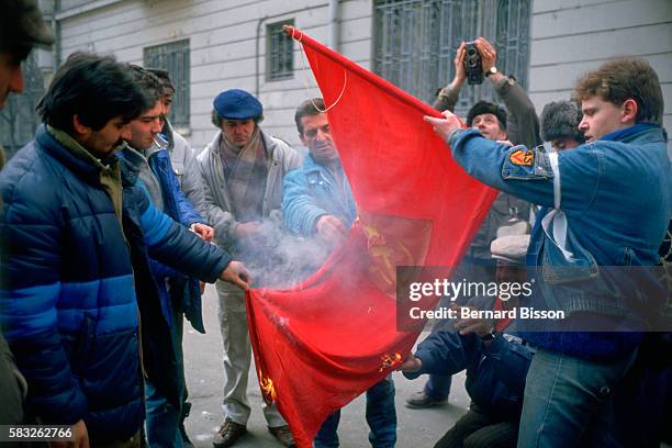 Demonstrators burn a Communist flag in protest of Romanian leader Nicolae Ceausescu.