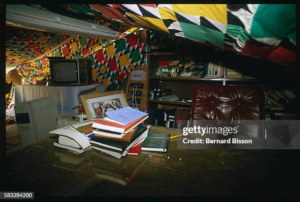 An office has been set up with large pieces of colored fabric and includes a television set, books, furniture and a picture of Colonel Quadhafi.