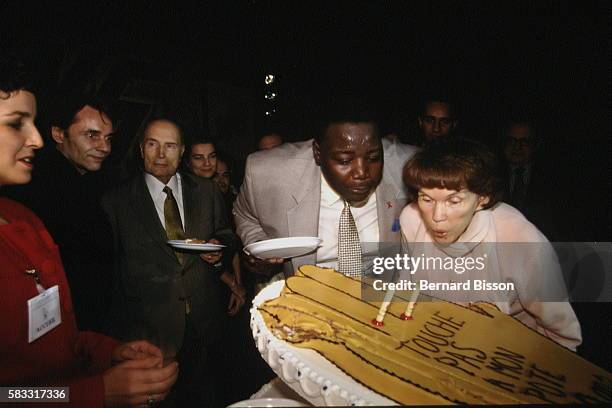 Danielle Mitterrand et Fode Sylla soufflent les bougies du gâteau.