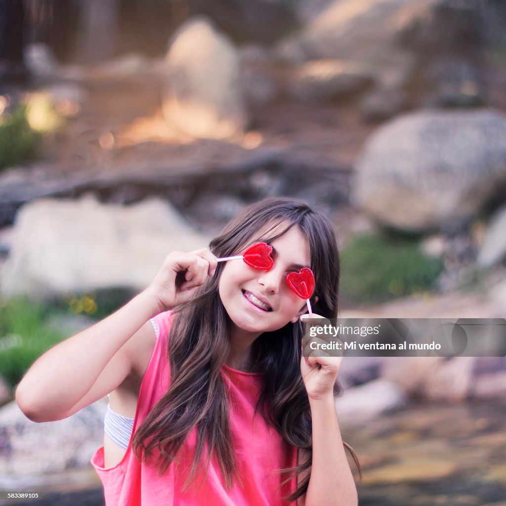 Beautiful teenager with heart-shaped lollipops