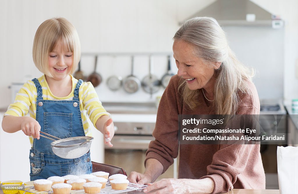 Granddaughter and grandmother baking cakes