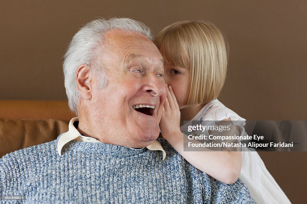 Granddaughter whispering to Grandfather