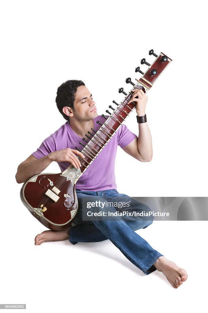 Young man playing the sitar