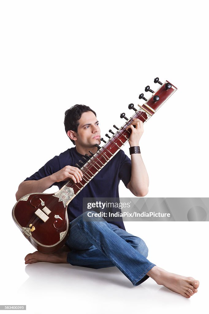 Young man playing the sitar