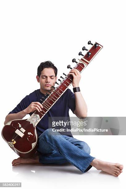 young man playing the sitar - sittar stock pictures, royalty-free photos & images