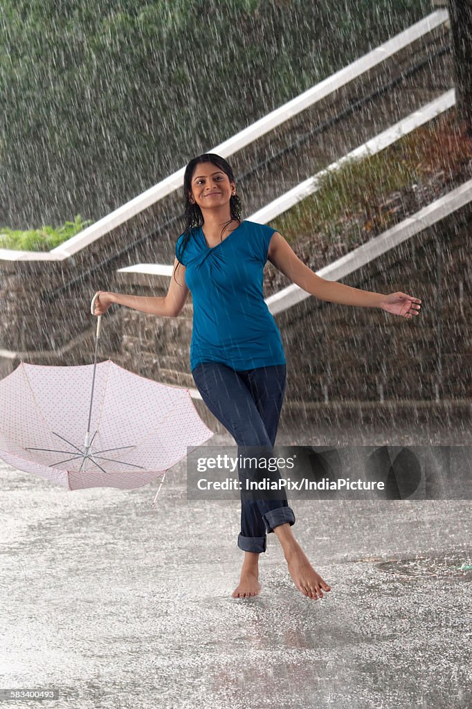 Woman with umbrella enjoying in the rain